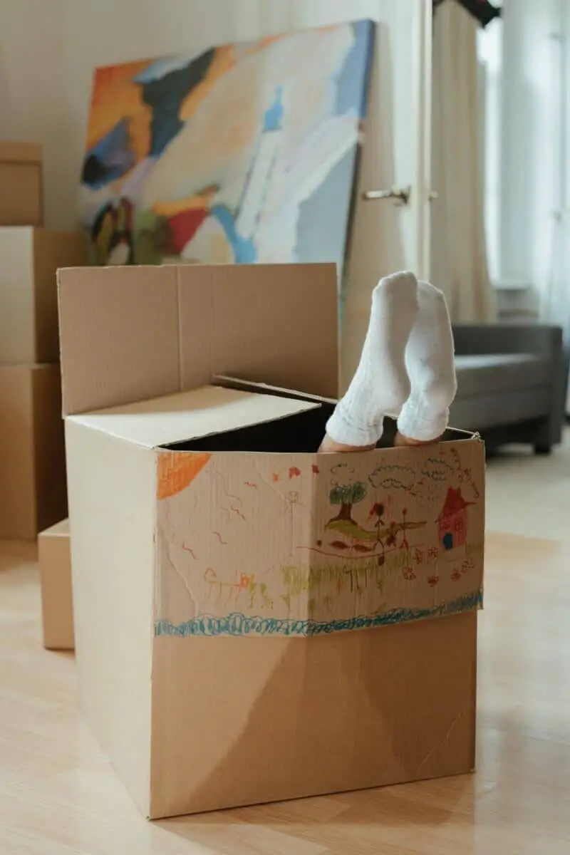 child playing in a cardboard box