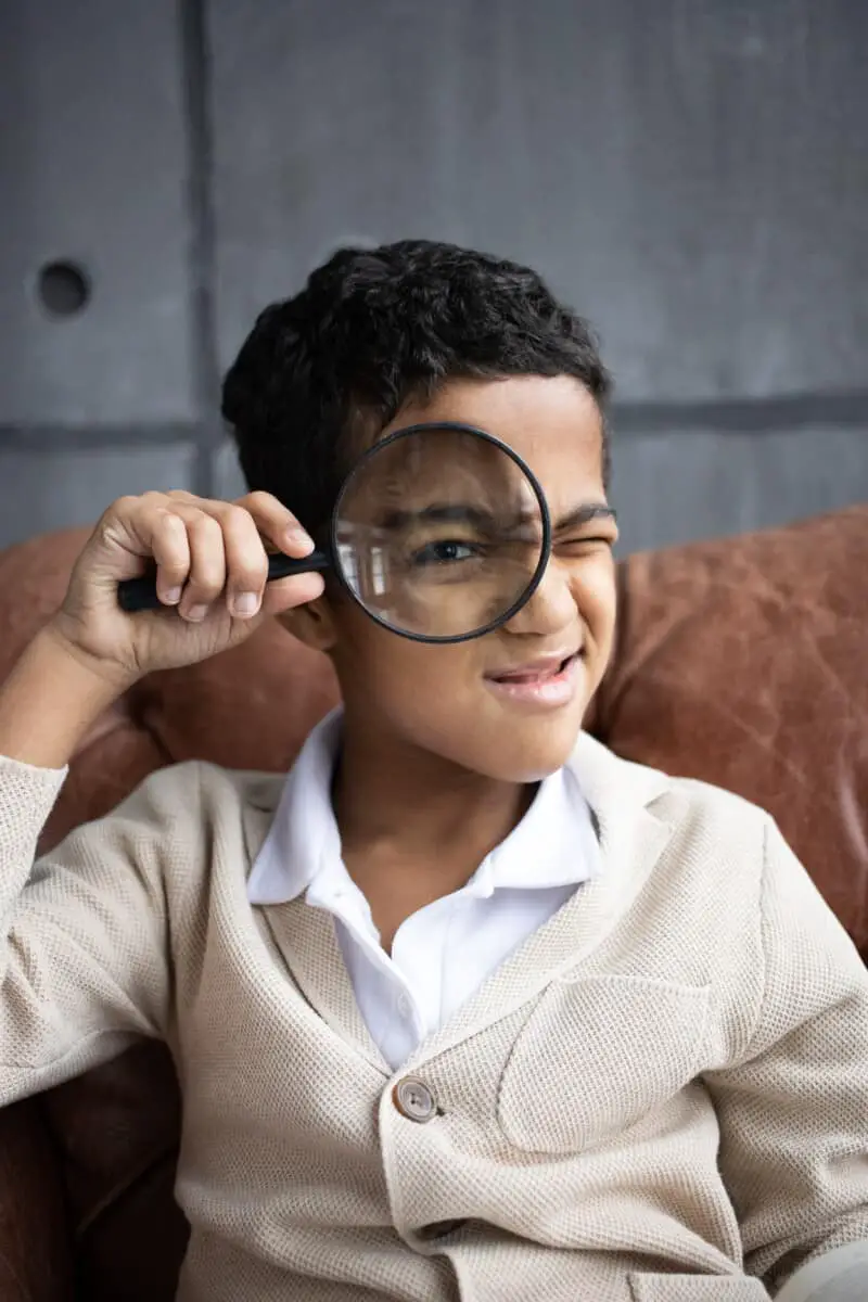 boy looking through magnifying glass