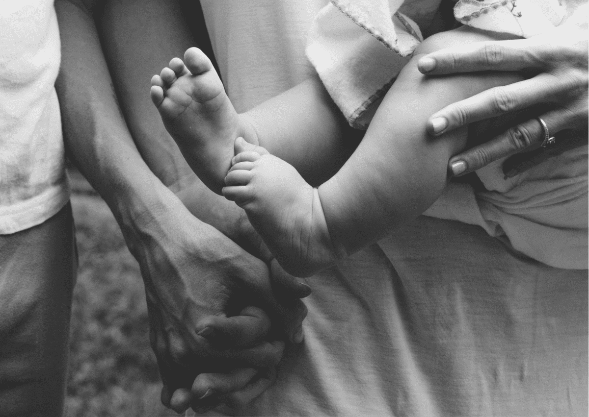Parents holding hands while holding baby
